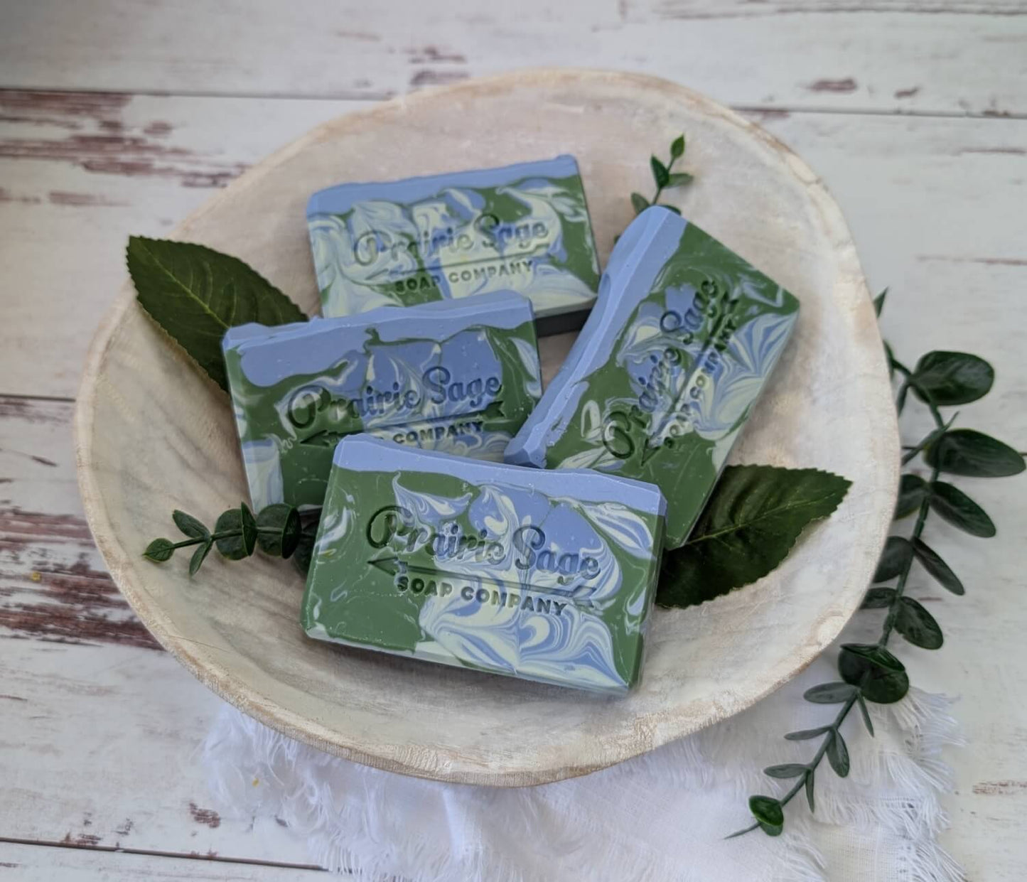 Blueberry Mint scented handmade soap in a bowl on a wooden table.