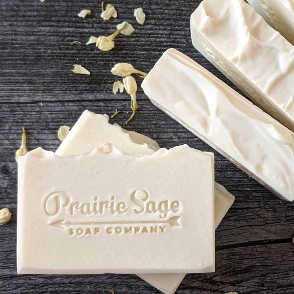White Gardenia handmade soap sitting on a wooden table.