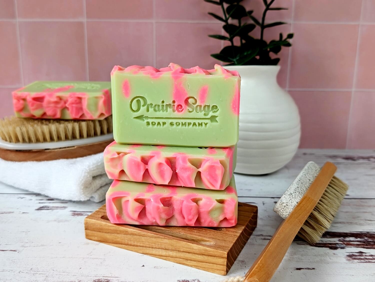 The Kiwi Watermelon handmade soap sitting on a wooden platform.