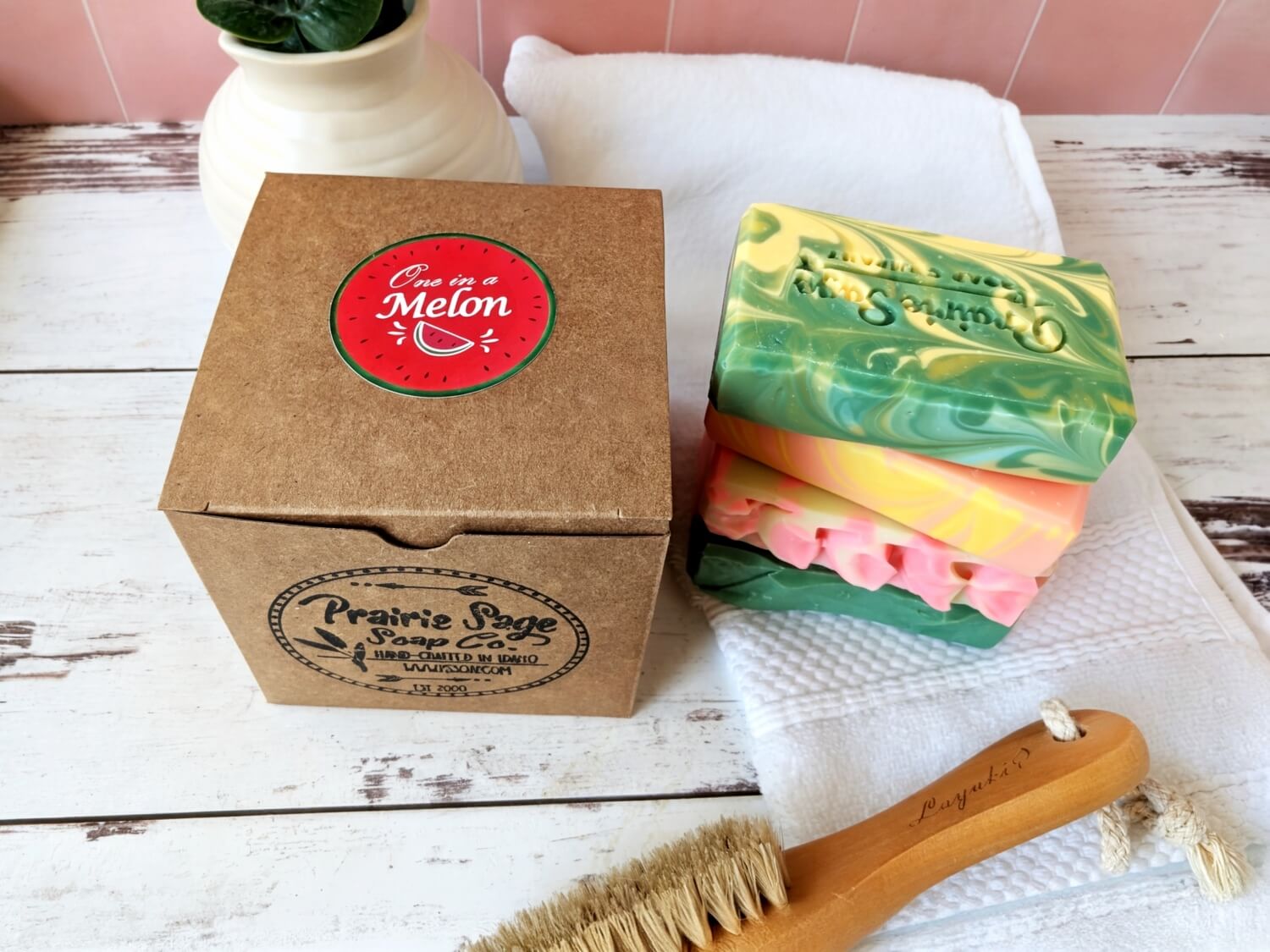 The Melon Medley Box alongside all four handmade soaps in the box stacked on each other