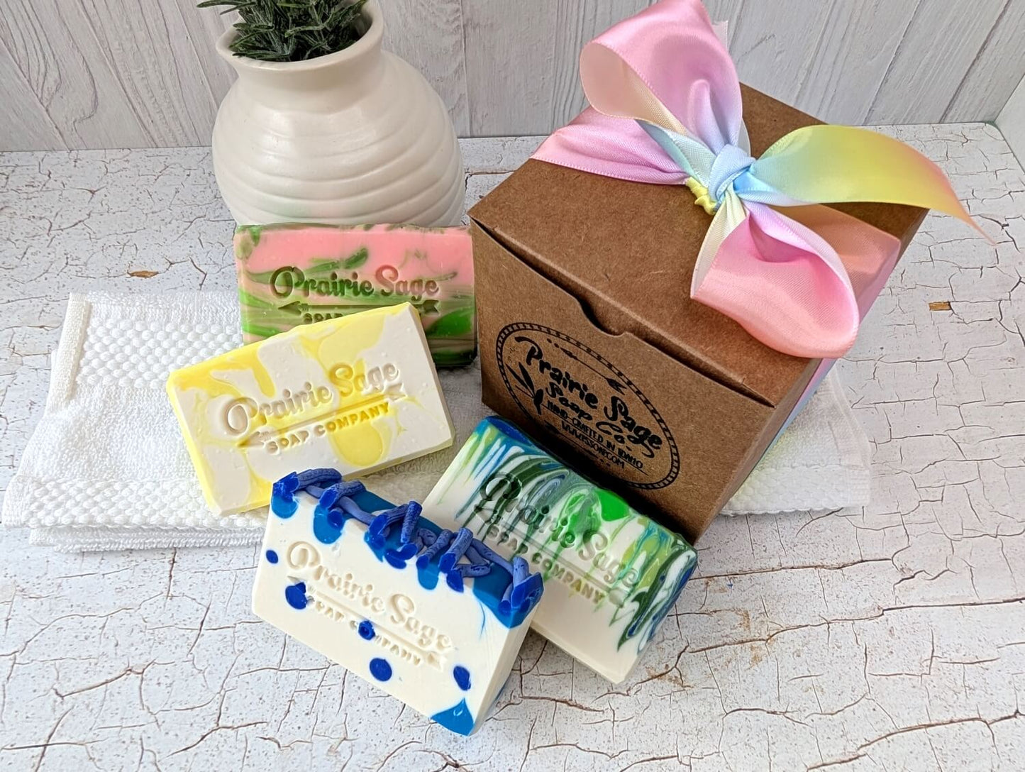 All four bars in the Showers and Flowers soap box collection sitting next to the box.