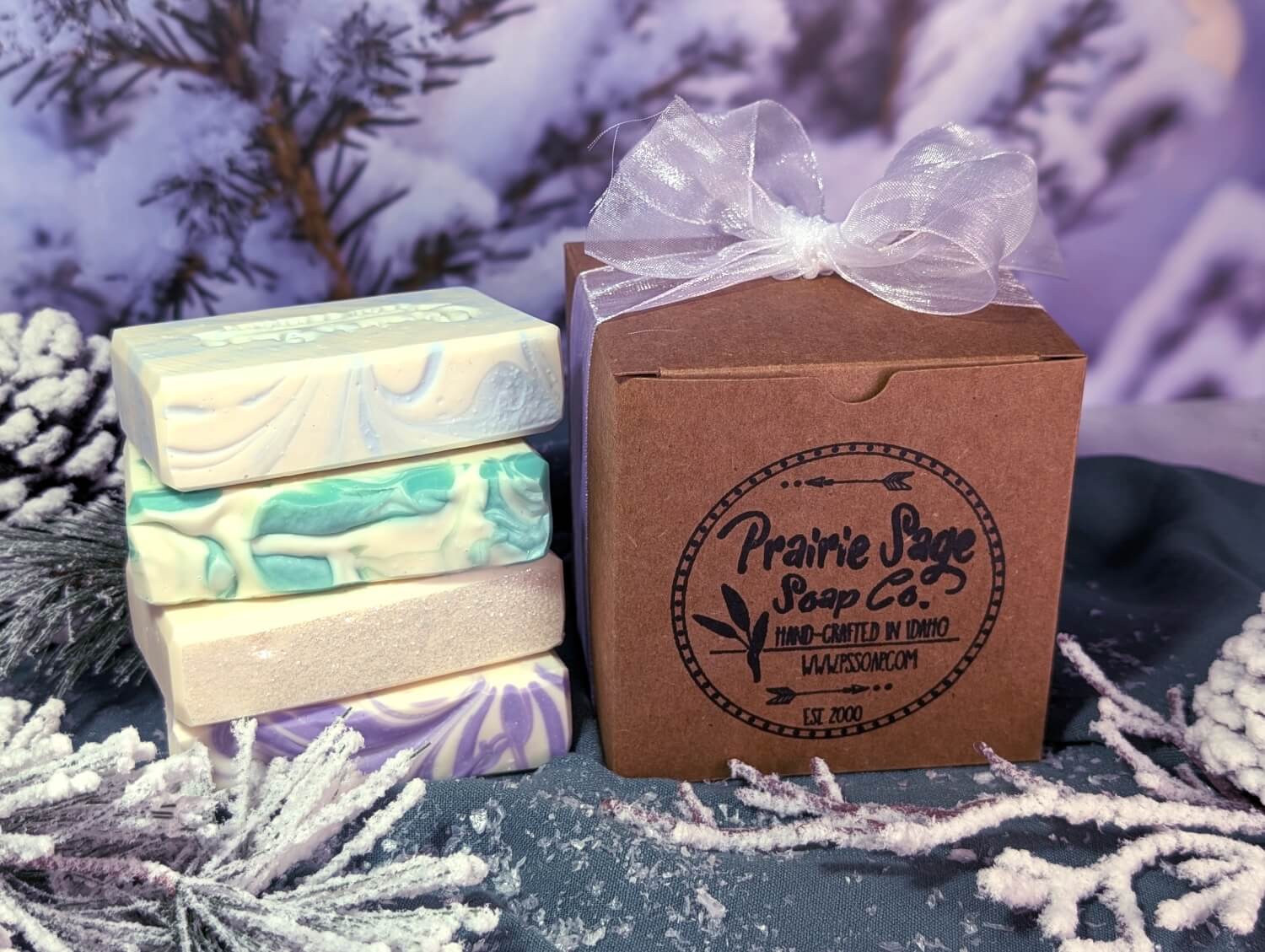 Winter Frost soap box next to a stack of the four different scents included in the box.